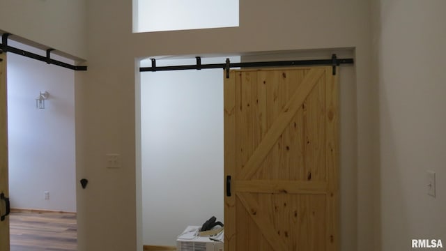 room details featuring a barn door and hardwood / wood-style floors