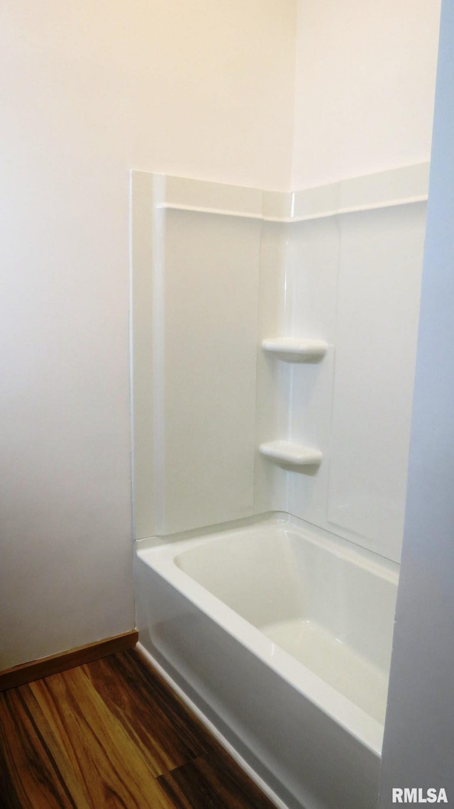 bathroom featuring wood-type flooring and bathing tub / shower combination