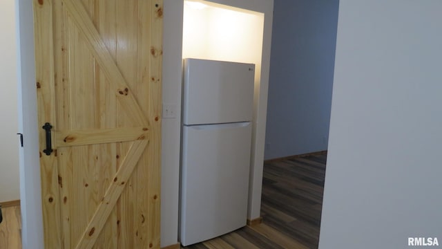 interior space with light brown cabinetry, dark hardwood / wood-style flooring, and white fridge