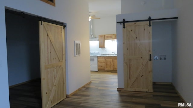 hallway with a barn door and dark wood-type flooring