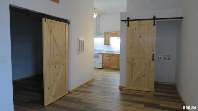 hallway featuring a barn door and dark hardwood / wood-style floors