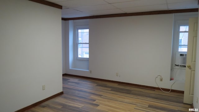 empty room with dark wood-type flooring and a drop ceiling