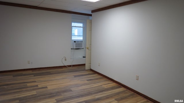 empty room with dark hardwood / wood-style floors and a paneled ceiling