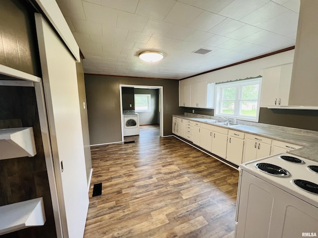 kitchen featuring washer / dryer, sink, white cabinetry, light hardwood / wood-style flooring, and white range with electric cooktop