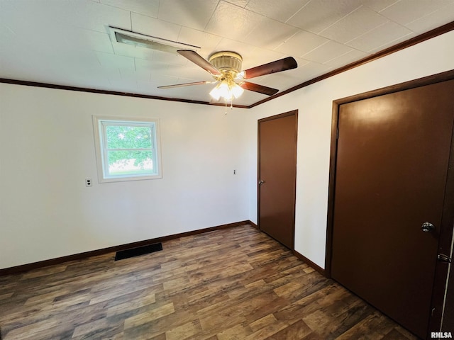 unfurnished bedroom with ornamental molding, dark wood-type flooring, and ceiling fan