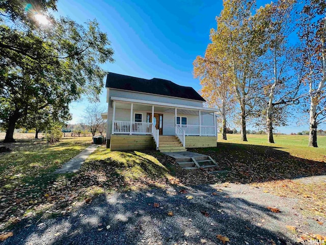 view of front facade with central AC, covered porch, and a front yard