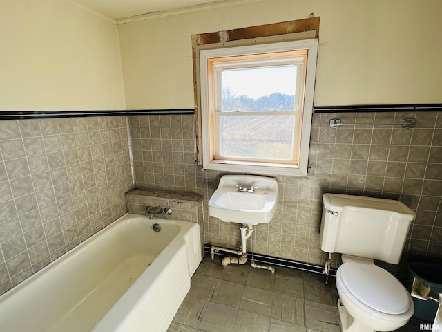 bathroom with sink, tile walls, a tub to relax in, tile patterned floors, and toilet