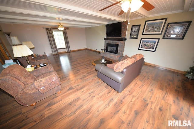 living room featuring crown molding, a fireplace, beamed ceiling, and wood-type flooring