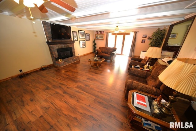 unfurnished living room with a fireplace, wood-type flooring, ceiling fan, and beam ceiling