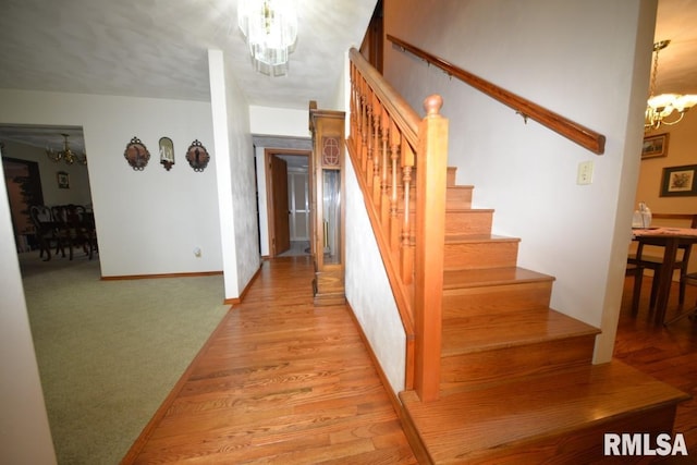 stairway featuring hardwood / wood-style floors and a chandelier