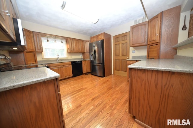 kitchen featuring stainless steel refrigerator with ice dispenser, sink, light hardwood / wood-style flooring, range, and black dishwasher