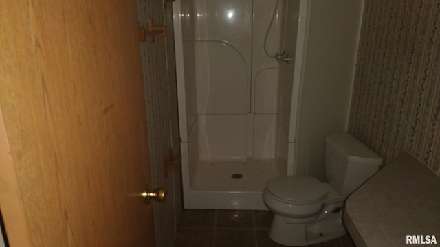 bathroom featuring tile flooring, walk in shower, and toilet