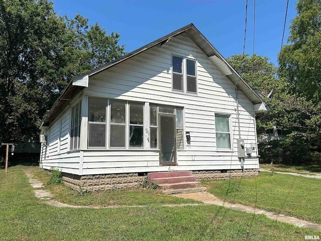 bungalow-style house featuring a front yard and a sunroom