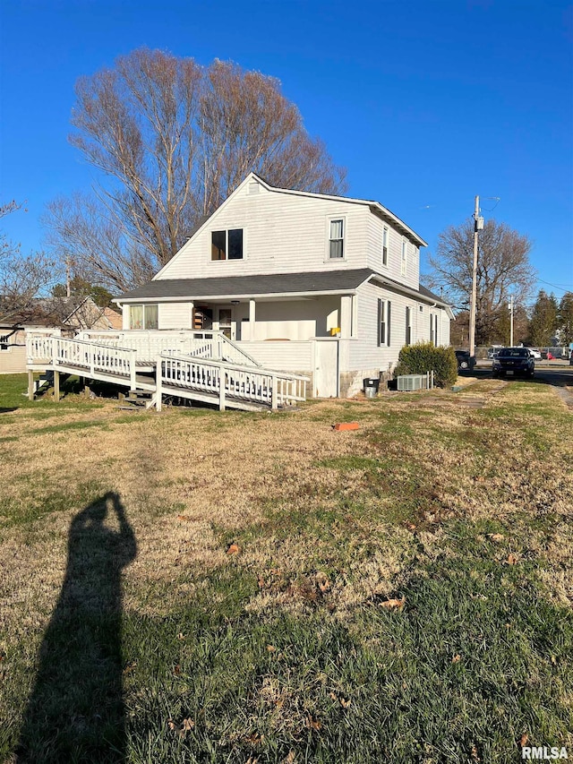 rear view of house with a deck and a yard