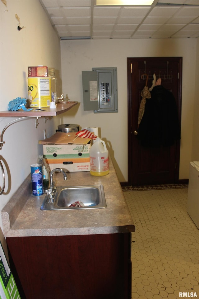 kitchen with a paneled ceiling, electric panel, and sink