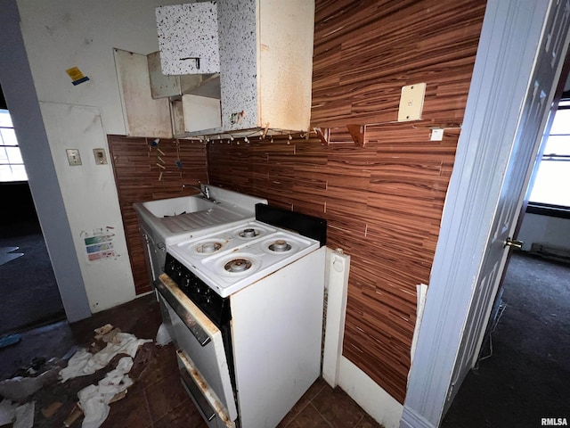 kitchen with white range with electric stovetop and dark tile flooring