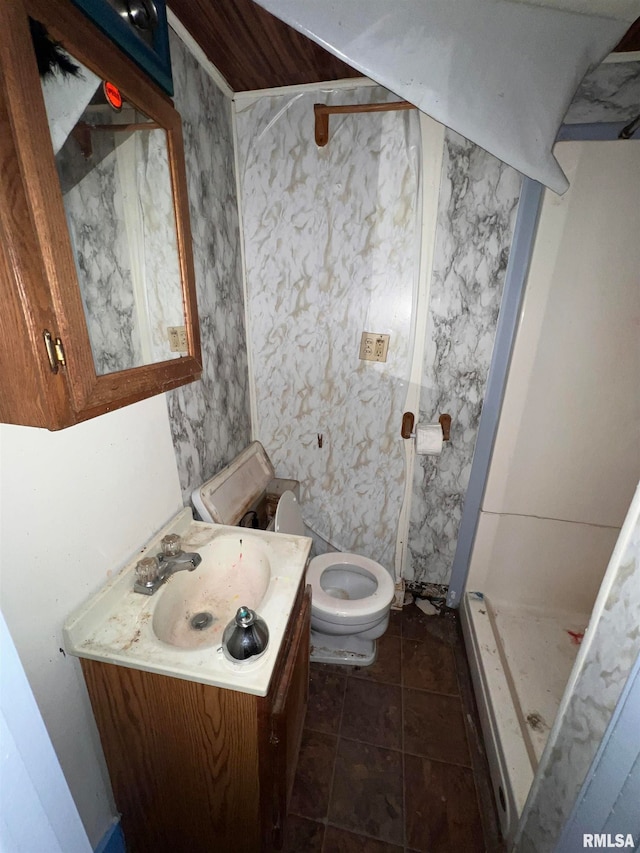 bathroom with tile flooring, toilet, walk in shower, and vanity with extensive cabinet space