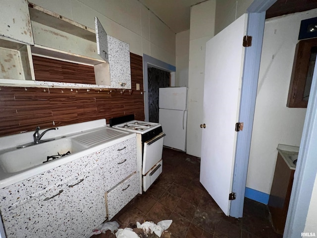 kitchen with white cabinetry, dark tile flooring, tile walls, sink, and white appliances
