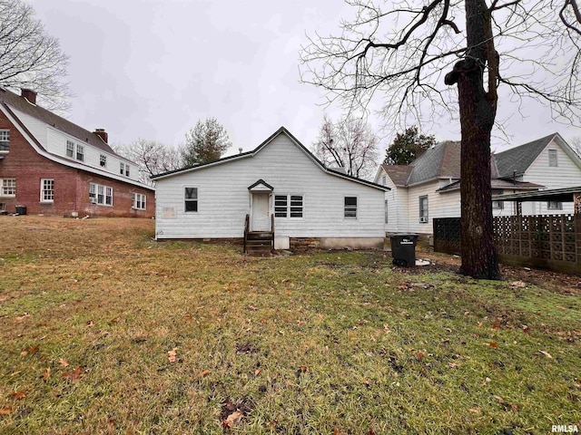 back of house with central air condition unit and a yard