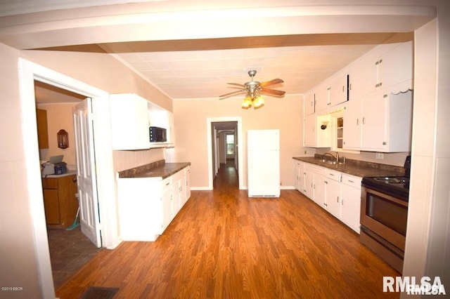 kitchen featuring ceiling fan, stainless steel range with electric cooktop, white cabinets, white fridge, and hardwood / wood-style flooring