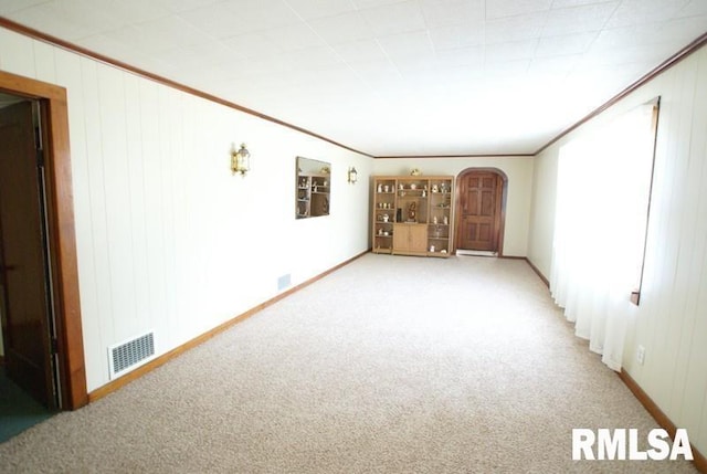 carpeted empty room featuring crown molding