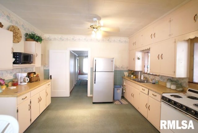 kitchen with ceiling fan, white cabinets, ornamental molding, sink, and white appliances