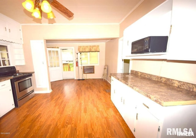 kitchen featuring light wood-type flooring, ceiling fan, white cabinetry, ornamental molding, and stainless steel electric range