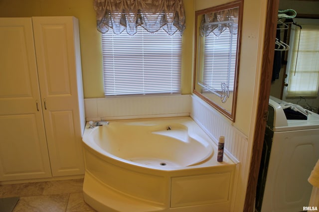 bathroom with plenty of natural light, a bath, and tile flooring