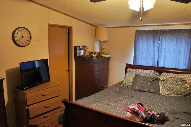 bedroom with a textured ceiling, crown molding, ceiling fan, and lofted ceiling