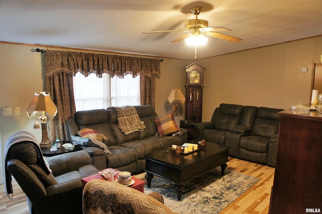 living room featuring ornamental molding, ceiling fan, and light wood-type flooring