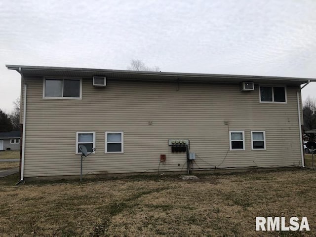 rear view of property featuring a lawn