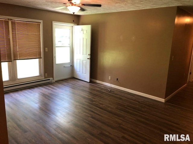 unfurnished room featuring dark wood-type flooring, a baseboard heating unit, ceiling fan, and a textured ceiling