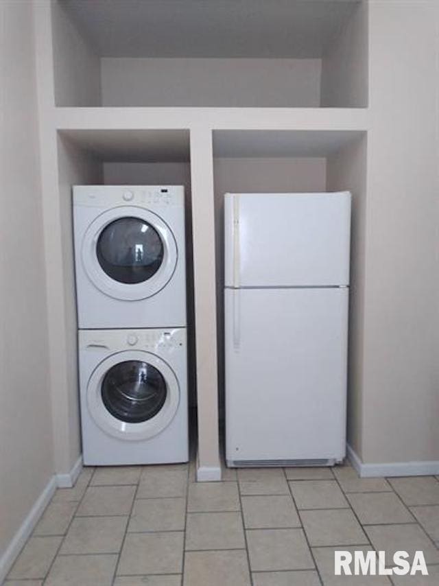 washroom with light tile patterned floors and stacked washing maching and dryer