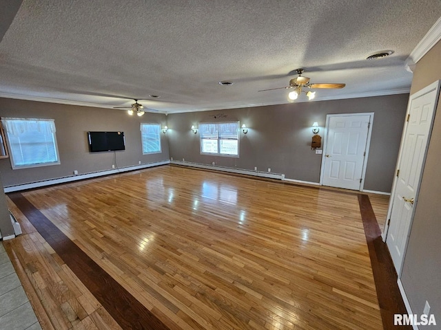 unfurnished living room featuring crown molding, a baseboard heating unit, ceiling fan, and light wood-type flooring