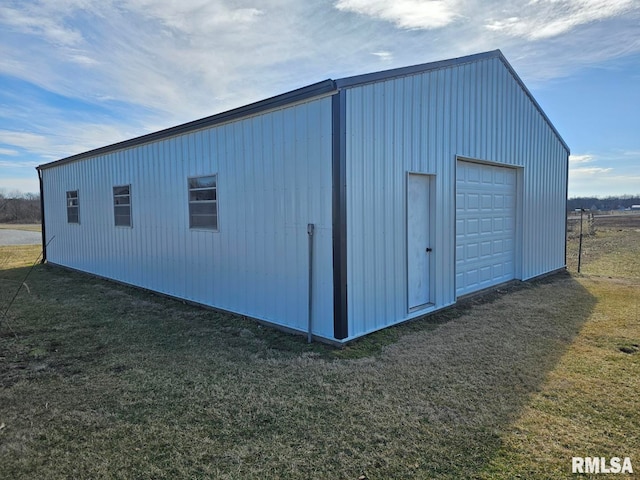 view of outdoor structure featuring a garage and a lawn