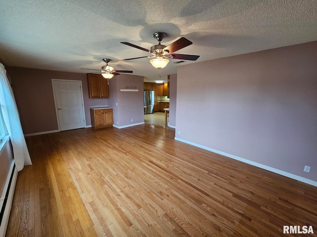 unfurnished living room featuring a baseboard radiator, ceiling fan, a textured ceiling, and light wood-type flooring