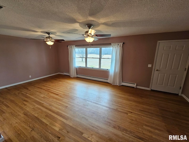 unfurnished room with a baseboard radiator, a textured ceiling, and light wood-type flooring