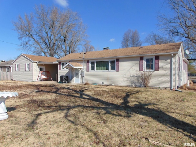 rear view of house featuring a lawn