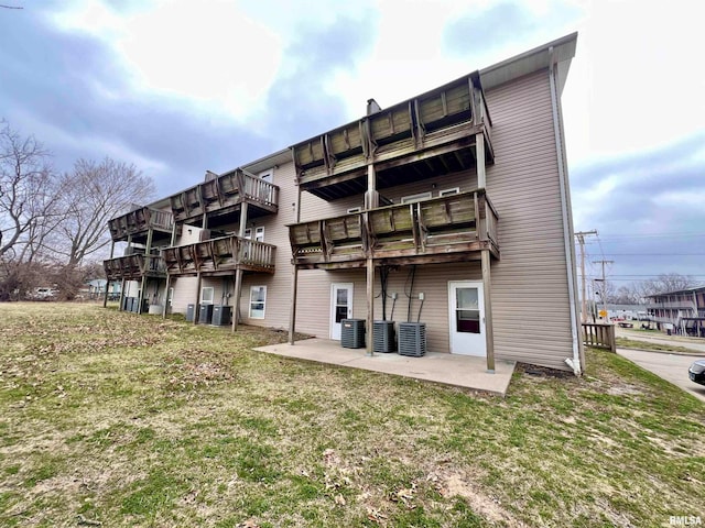 back of property featuring central AC, a patio, and a lawn