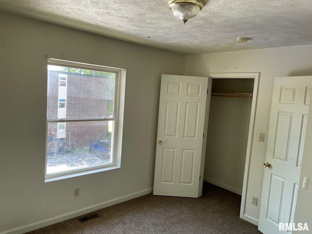 unfurnished bedroom with a closet, carpet, and a textured ceiling