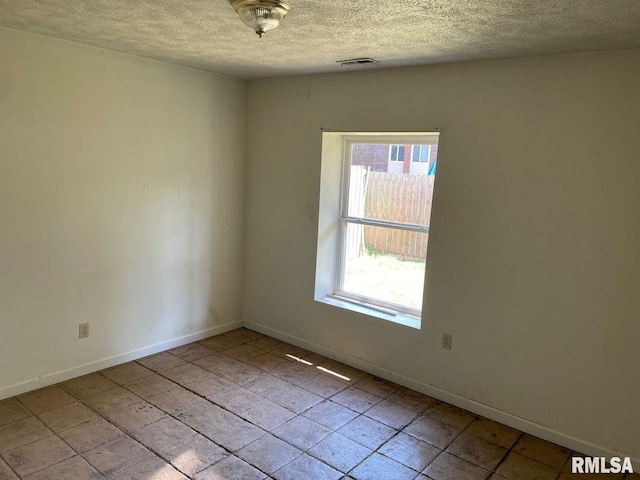 unfurnished room featuring a textured ceiling