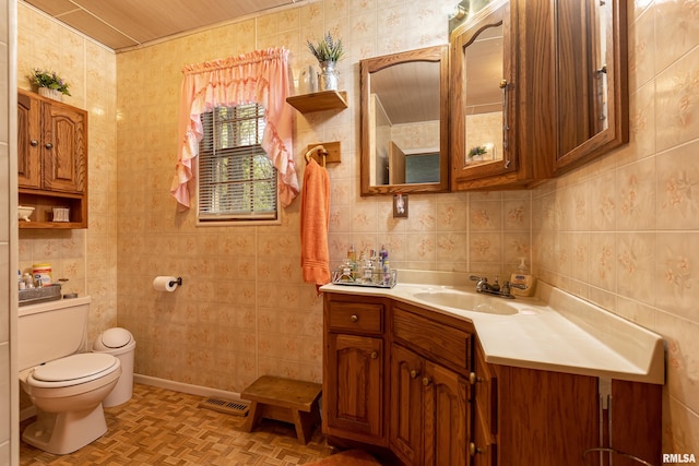 bathroom featuring toilet, tile walls, parquet flooring, tasteful backsplash, and vanity