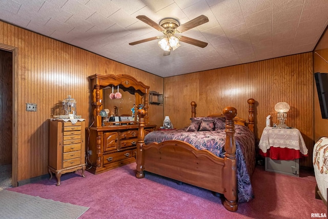 bedroom featuring wood walls, ceiling fan, and carpet