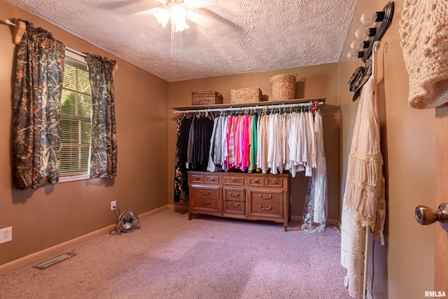 spacious closet with ceiling fan and carpet flooring