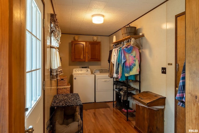 washroom with light hardwood / wood-style flooring, cabinets, and independent washer and dryer