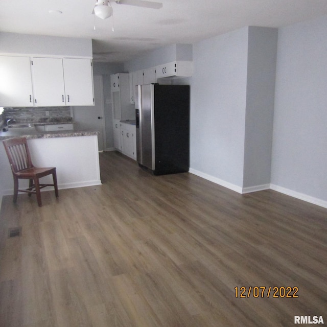 kitchen featuring white cabinets, ceiling fan, dark wood-type flooring, and stainless steel fridge