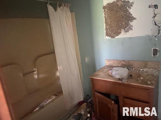 bathroom featuring shower / tub combo and vanity