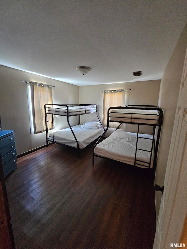 unfurnished bedroom featuring a textured ceiling and dark hardwood / wood-style flooring