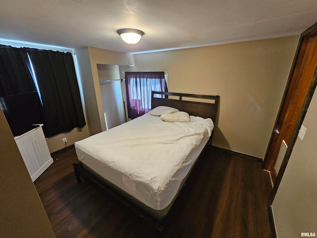 bedroom with dark wood-type flooring