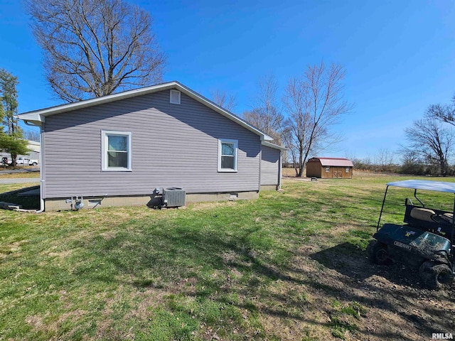 view of home's exterior with central AC, a lawn, and a storage unit